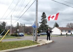 Man with tinfoil hat holding upside-down Canada flag.