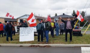 Crowd of fascists with a bunch of Canadian flags and signs about fake news and bible quotes.